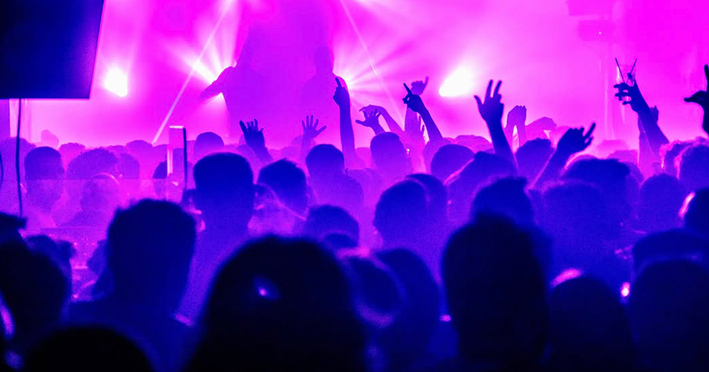 This article is about Pride parties taking place in Dublin. In the photo, people dancing in a club with purple and pink lights.