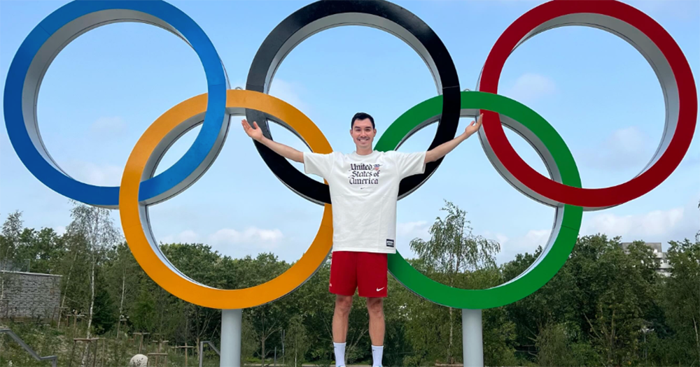 Erik Shoji posing in front of the Olympic rings in Paris.