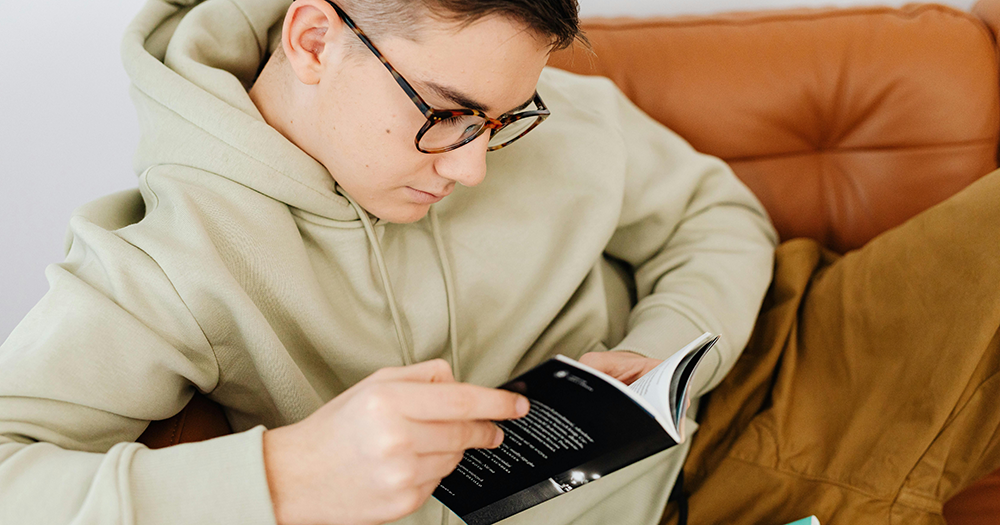 This article is about what fiction can teach boys about masculinity. The image is of a teenage boy reading a book.