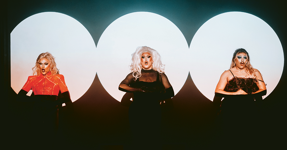 Drag trio Haus of WIG under the spotlight on stage.