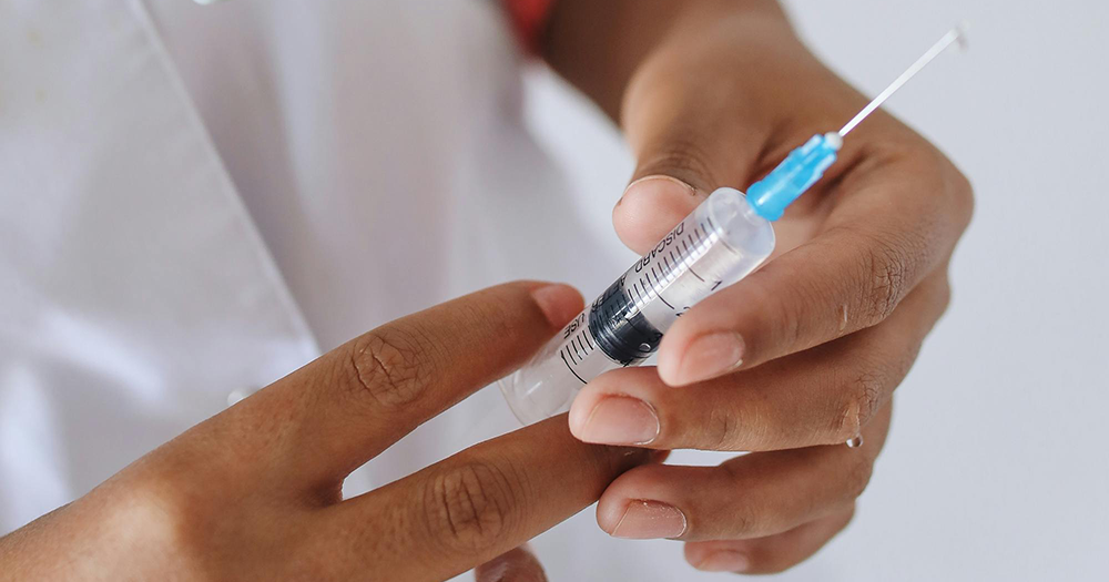 Hands holding a needle, like the HIV injection.