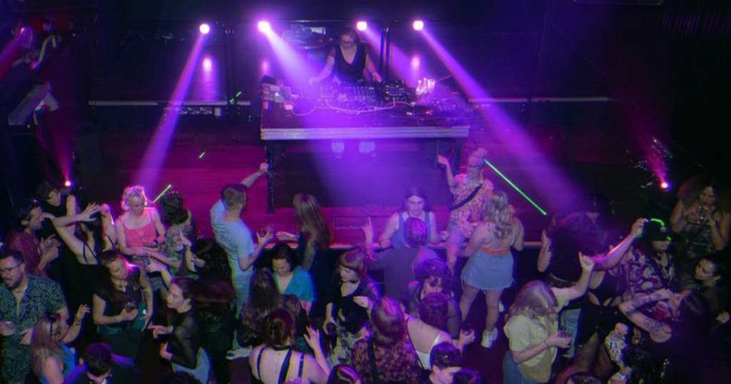 This article is about nightclub King being back for Pride. In the photo, people dancing in a club.