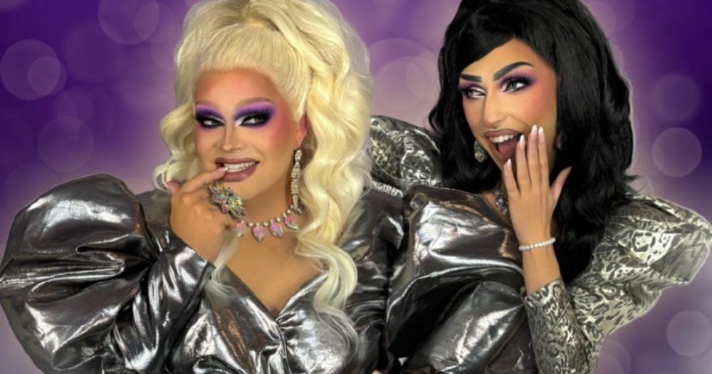 The Misses, Miss Taken and Miss Roots, cheekily posing together wearing shiny dresses in front of a purple background.