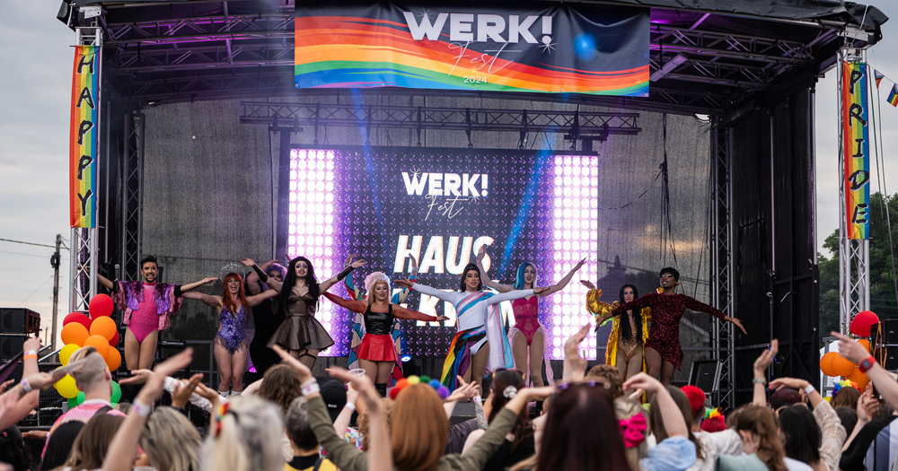 Photo of Mullingar Pride, with drag performers on stage while the crowd below cheers.