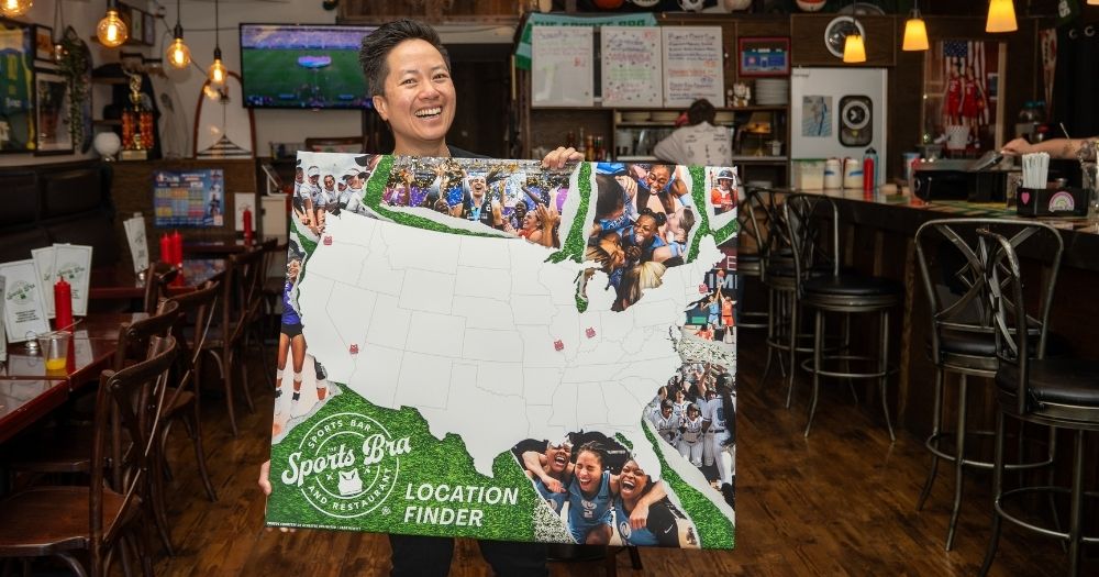 Owner of The Sports Bra, Jenny Nguyen, holding a pinned map