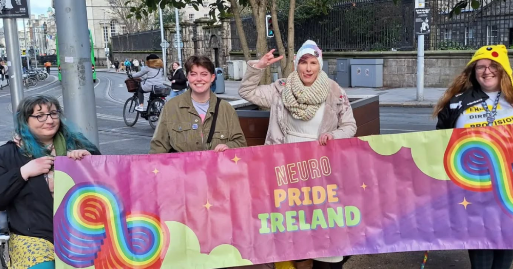 Neuro Pride Ireland members hold up a banner.