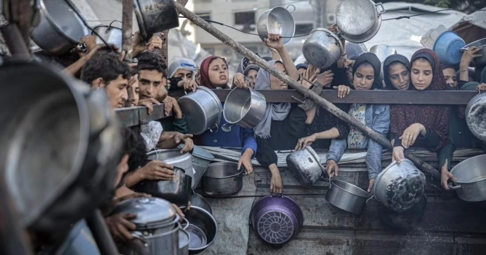 This article a famine alert in Gaza. In the photo, Palestinians trying to access food.