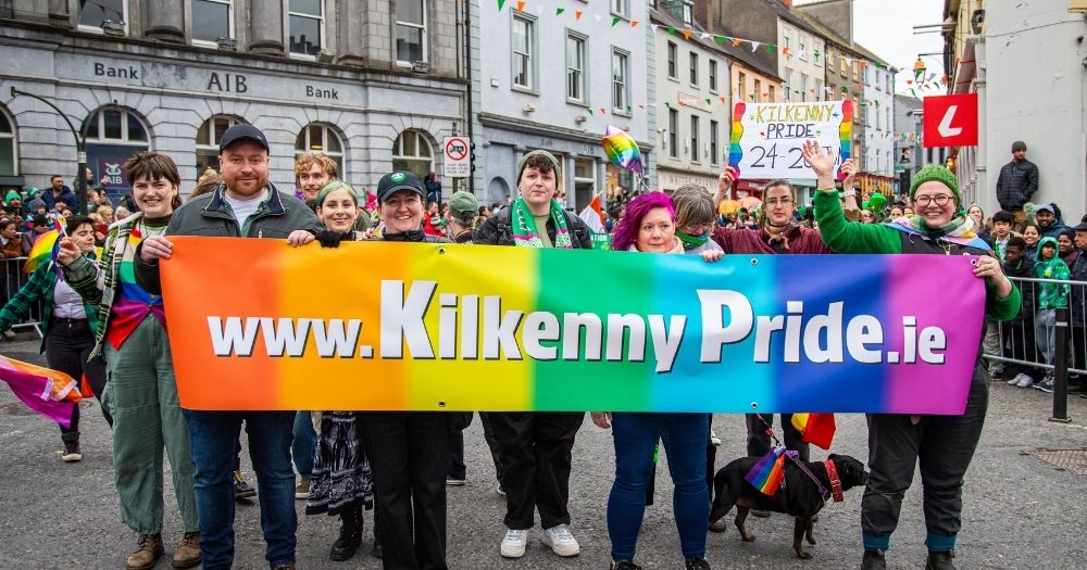 A group of people at the St. Patrick's Day parade in Kilkenny holding a banner for Kilkenny Pride.