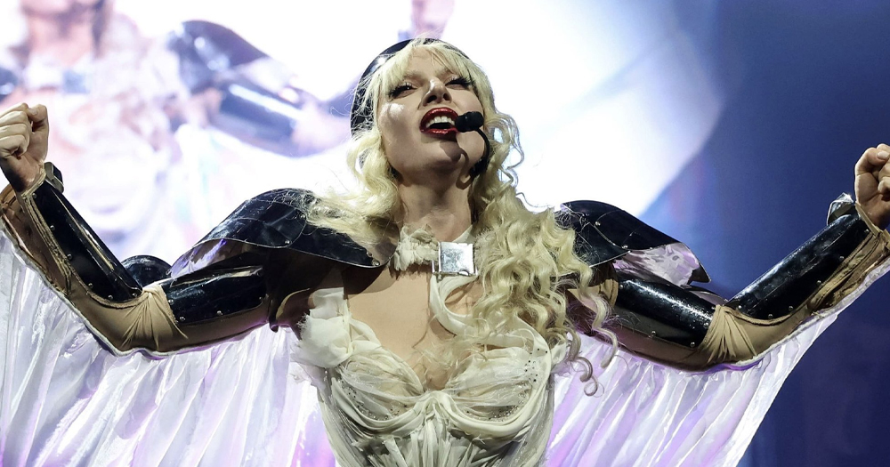 Lady Gaga performing at her concert, wearing an angel costume.