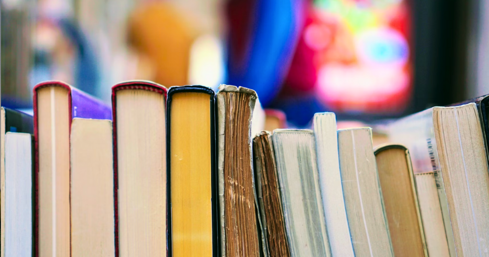 Image shows stacked books relating to the article covering John Boynes recent controversy and his Polari Prize nomination