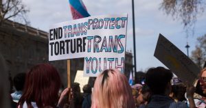 This article is about a new model of trans healthcare developed by the HSE. In the image, people protesting for trans rights.