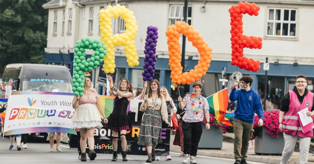 The Laois Pride parade from 2024. Several people carry different colour balloons arranged to spell out 