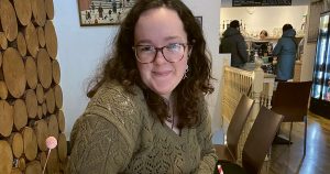 LGBTQ+ secondary school student Tara McCarthy sitting and smiling.