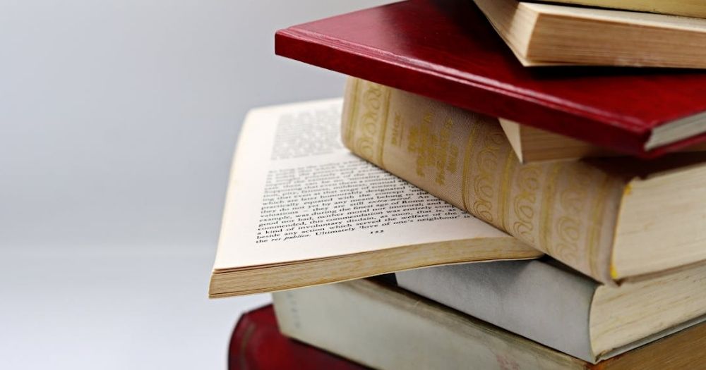 This article is about a literary prize being cancelled over the inclusion of author John Boyne. Image portrays a stack of books, most of them closed with one of them revealing a page.