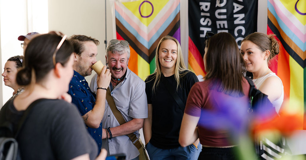 Photos of Vancouver Queer Irish members as they celebrate Marriage Equality, smiling and chatting in a room full of people with progress Pride flags in the background.