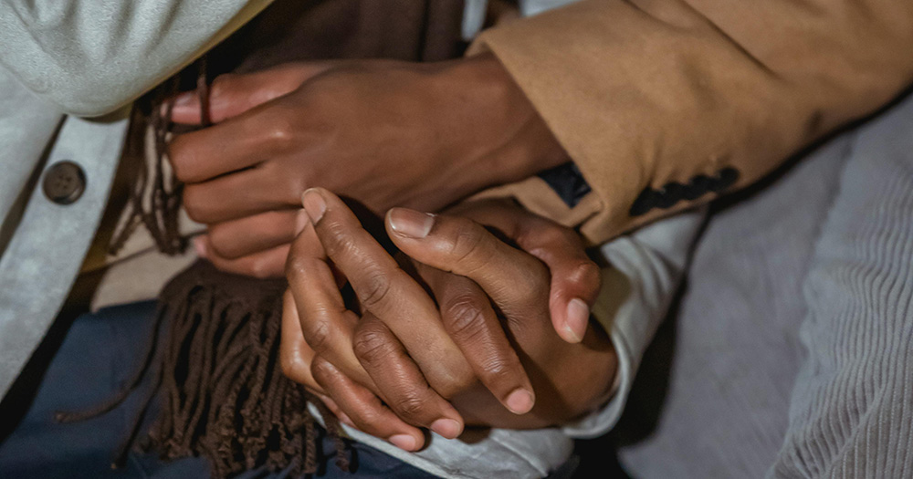 This article is about Burkina Faso criminalising homosexuality. The image is a close up of two men holding hands.