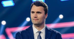 Photo of Charlie Kirk on a stage looking at the audience.