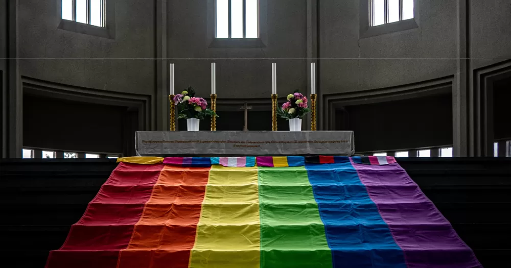 This article is about LGBTQ+ inclusion in the Church of Ireland. In the photo, an altar with a large Pride flag on the steps leading up to it and other smaller flags for different queer identities.