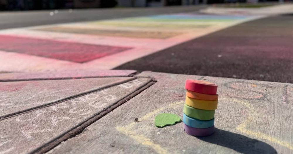 Image shows chalk and rainbow stripes on the Pulse nightclub rainbow crosswalk.