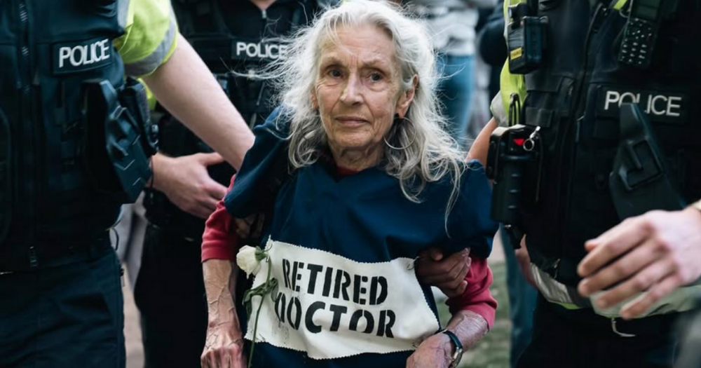 Image shows an eledery person being arrested at a Palestine Action protest