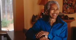 Beverly Glenn-Copeland smiling, looking into the distance. He wears a blue shirt.
