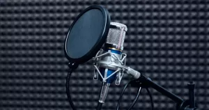 This article is about a Belfast LGBTQ+ radio. In the photo, a radio microphone in a dark insulated room.