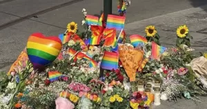 Flowers and rPride flags sit at a vigil for a anti LGBTQ+ hate crime that took place in Norway in 2022. A new report has revealed an increase in LGBTQ+ hate crimes in the past five years