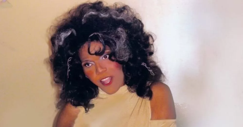 Trans activist Miss Major Griffin-Gracy posing for a photo while wearing a pale yellow dress.