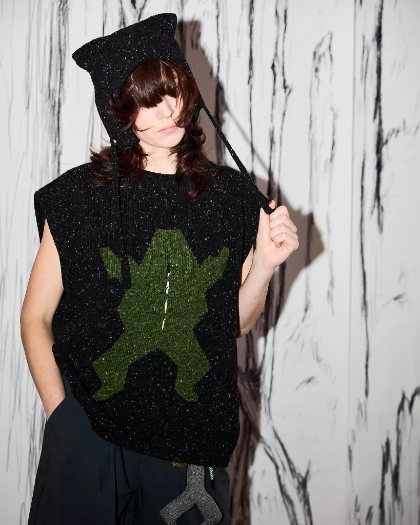 A model for Mar Knitwear's new collection with Donegal Yarns wears a black vest with a frog on it.