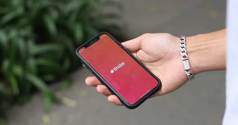 A hand holding a phone open on Tinder.