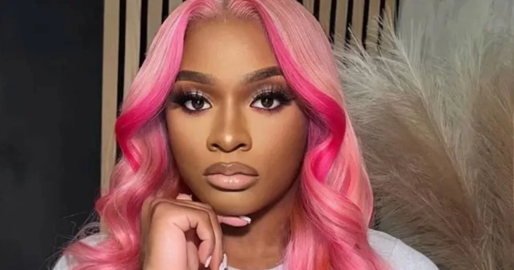 Image shows Girlalala with her hand resting on her chin.