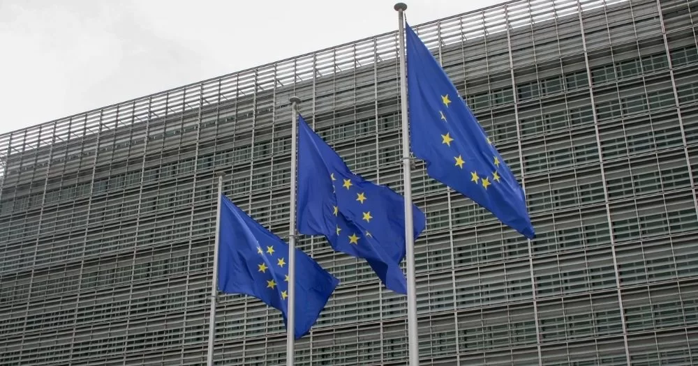 This article is about the EU Enlargement process. In the photo, three EU flags flying in the sky.