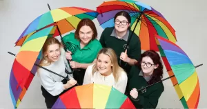 Young people hold rainbow umbrellas, Belong To is launching its Stand Up Awareness Week 2025