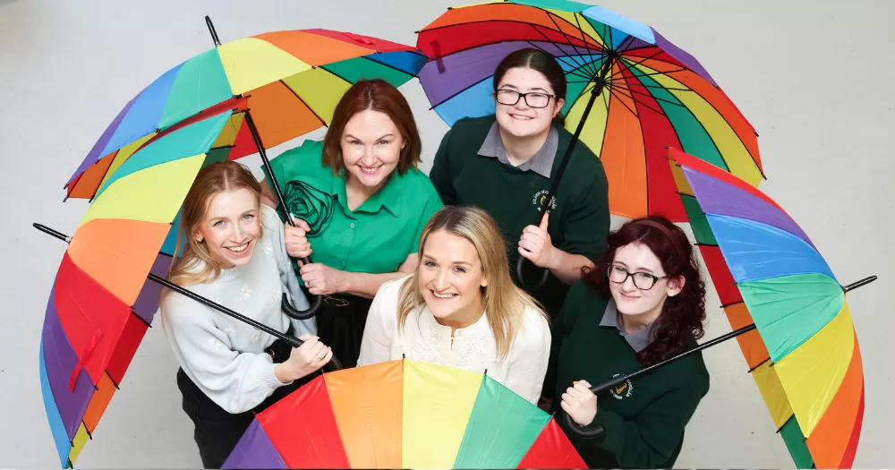 Young people hold rainbow umbrellas, Belong To is launching its Stand Up Awareness Week 2025
