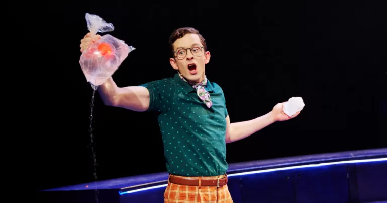 Cast member from Gold in the Water hold a punctured plastic bag with goldfish inside