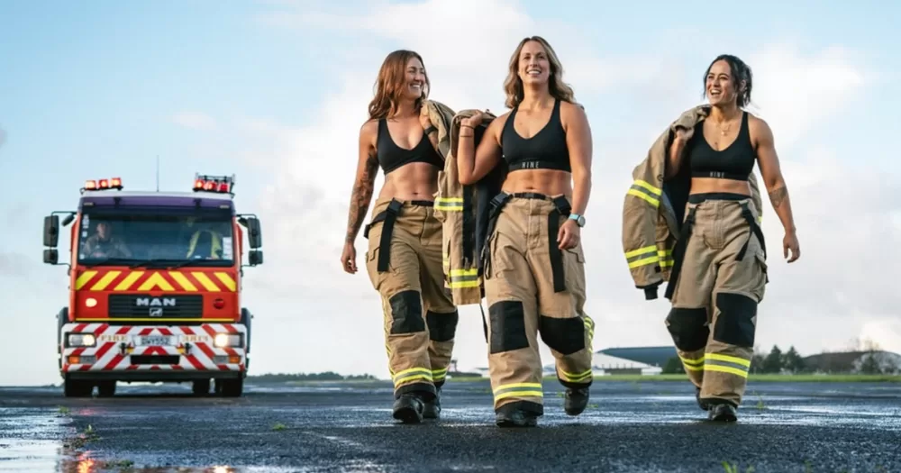Some of the women invloved in the firefighter calander pose together with a truck nearby