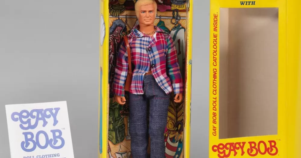 The original Gay Bob doll and its box that looks like a closet, along with a fashion catalogue for different styling choices.