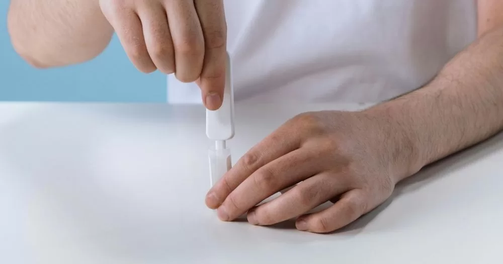 A pair of hands holds a HIV at home self-test, the kind that is delivered through Grindr.