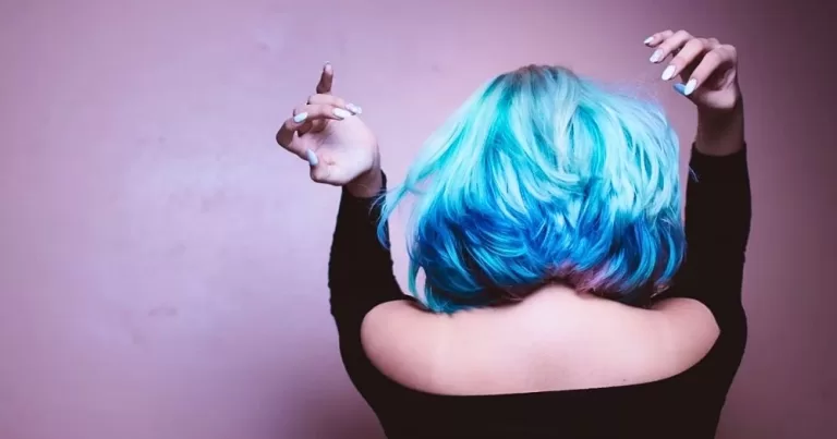 A person with a bright blue hair style facing away from the camera.