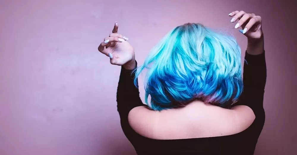 A person with a bright blue hair style facing away from the camera.
