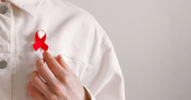 Image shows a person in a white shirt with a red ribbon. This image is being used to accompany a story about access to PrEP in Ireland.