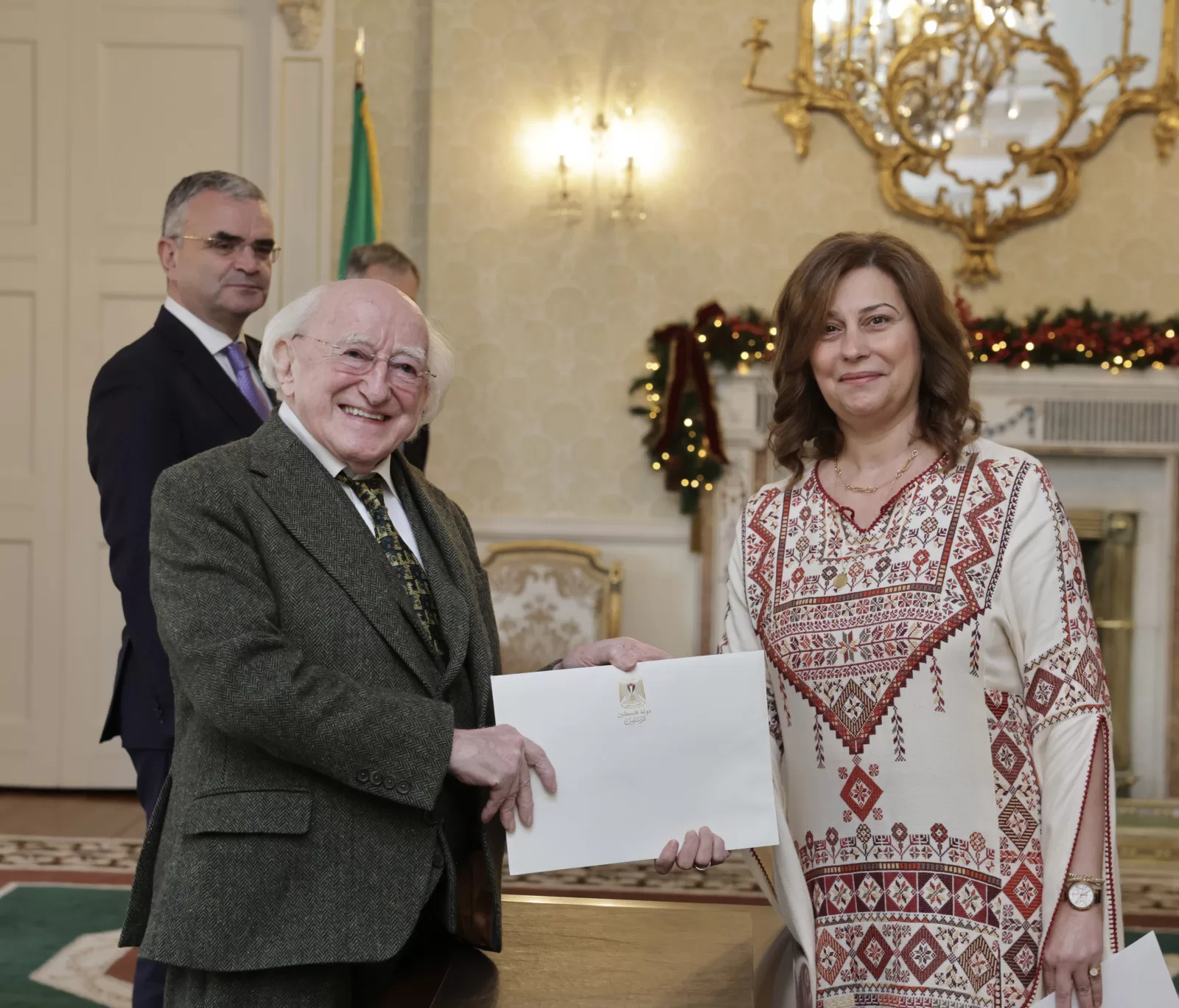 Michael D. Higgins presents a document to Jilan Wahba Abdalmajid, the Palestinian Ambassador to Ireland.