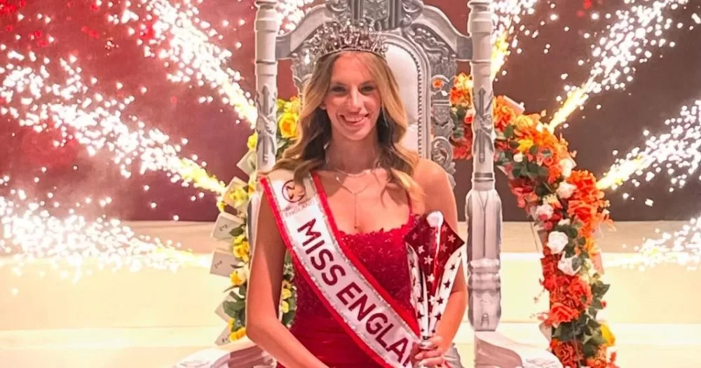 Grace Richarson, who became the first openly gay Miss England, sitting on a chair with the crown and sache after her victory.