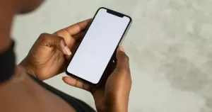A person holds a phone in their hands. This image is being used to accompany an article about queer apps.