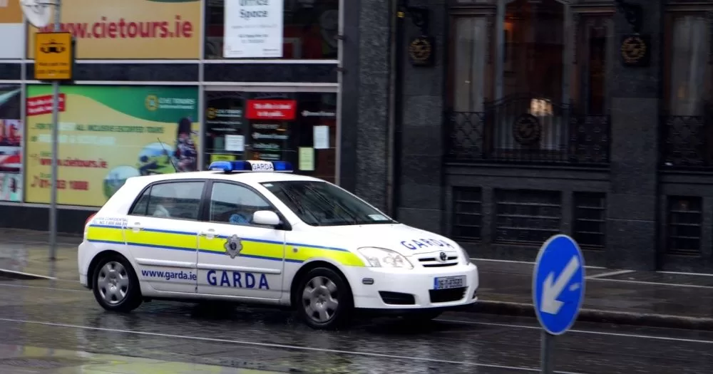 This article is about a terror attack planned on a Galway mosque. IN the photo, a Garda car driving on a street while it's raining.