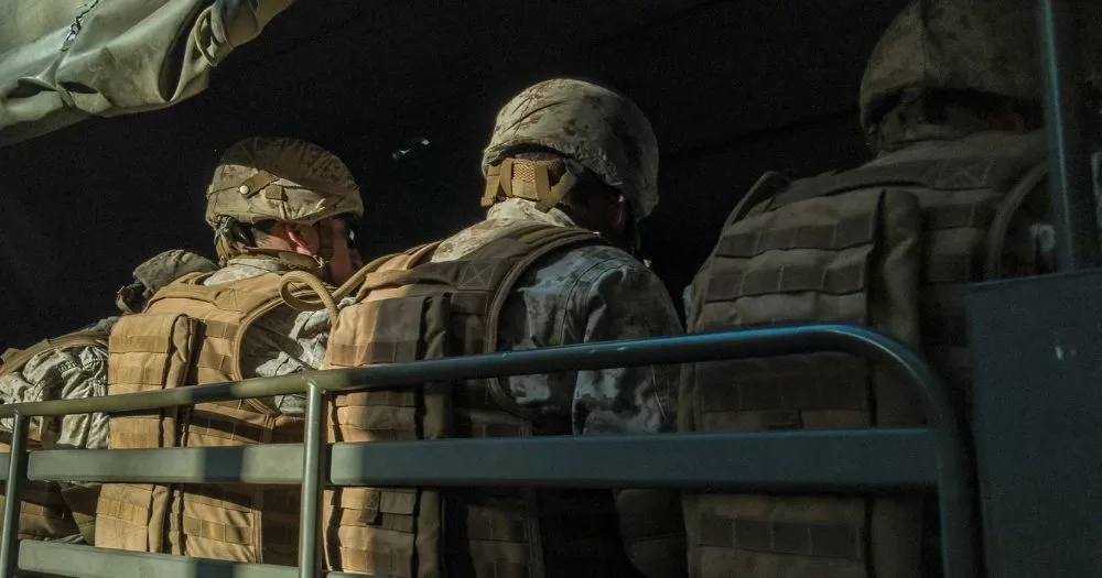 A group of military personnel in uniform sit in a truck. This image is being used to accompany an article about the US's trans military ban.