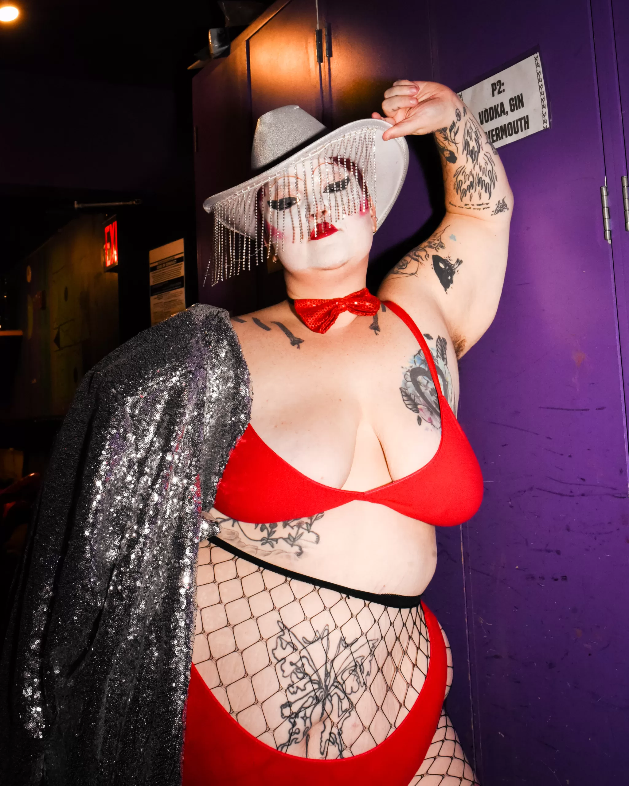 A performer with Dykes and Dolls poses in lingerie and a cowboy hat.