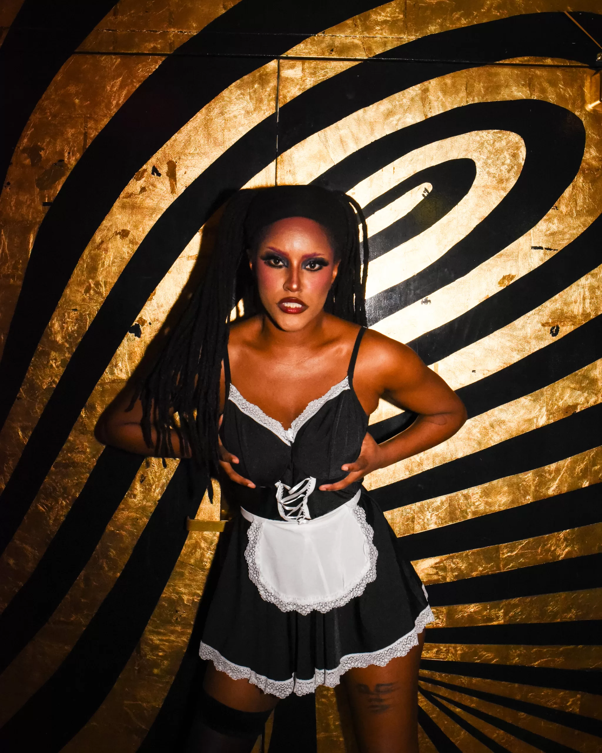 A performer from Dykes and Dolls poses in a maid costume.