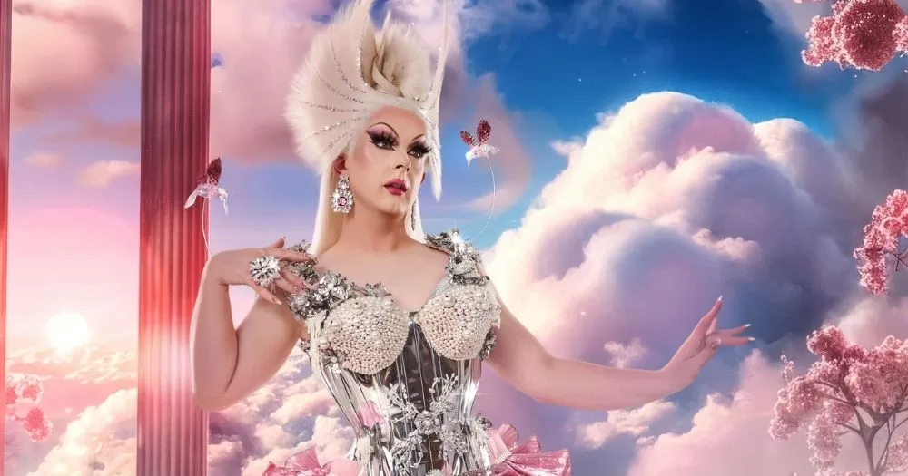 Bonnie Ann Clyde poses in front of a background of clouds.