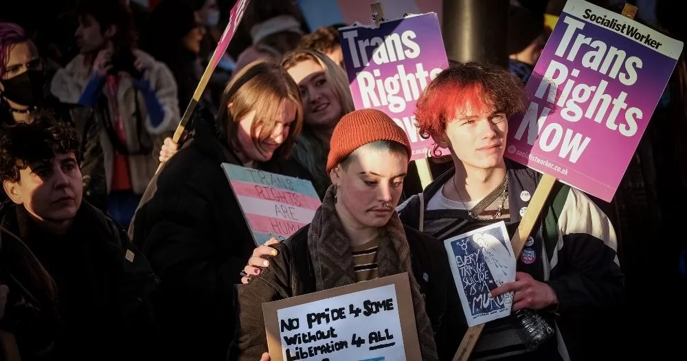 This article is about a UK nurse's case against the NHS and a trans doctor. In the photo, people protesting fro trans rights.